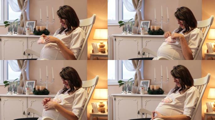 孕妇拿着婴儿鞋坐在摇椅上