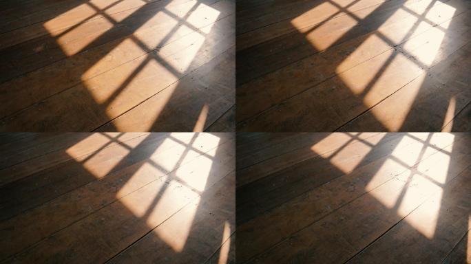 阳光透过窗户投射在旧木地板上