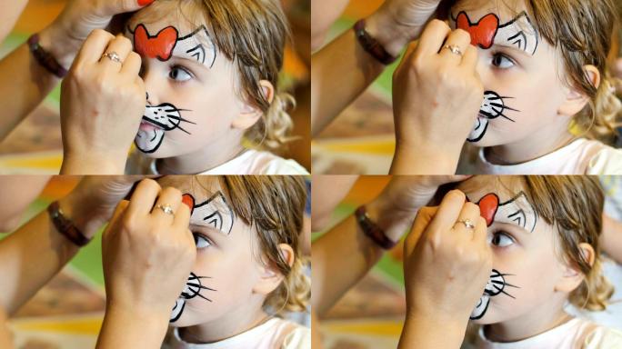 小女孩在狂欢节上被画成猫的脸