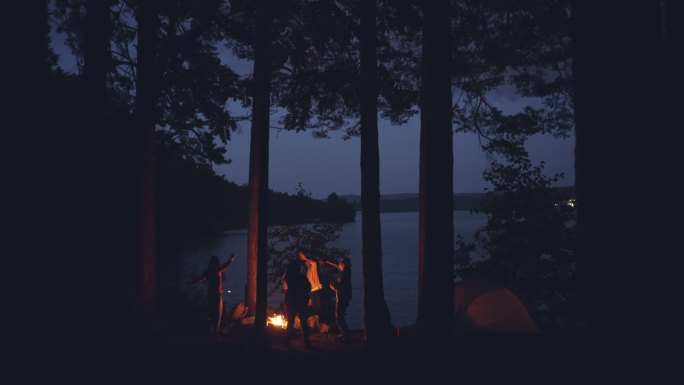 夏天的夜晚，年轻人在湖边围着篝火跳舞