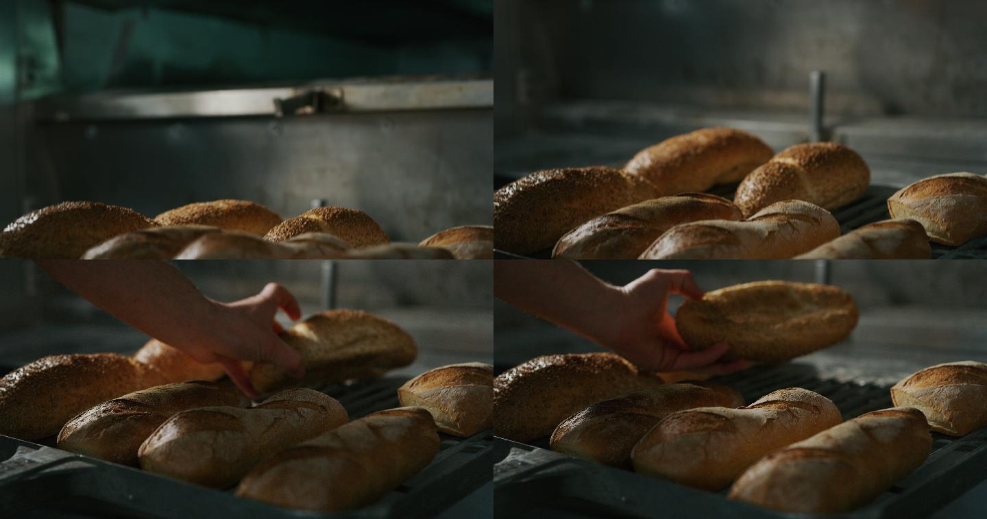 面包师从烤箱里拿出面包