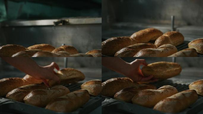 面包师从烤箱里拿出面包