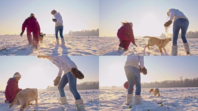 母亲和女儿带着一只小狗在雪地里玩耍