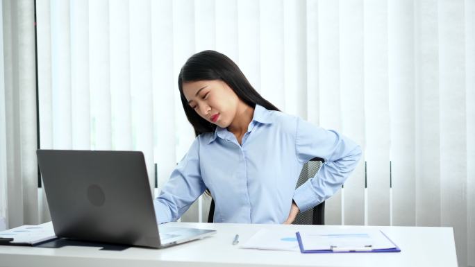 商业女性在办公室感到腰部疼痛
