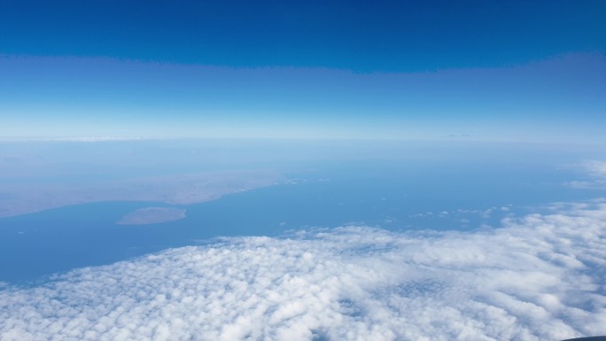 飞机在云层覆盖的海洋和陆地上空飞行的4k视频