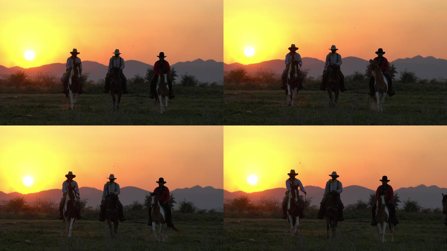 日落时骑着马匹的牛仔