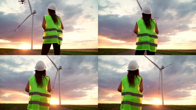 女性生态专家操纵着无人机在风车上工作。