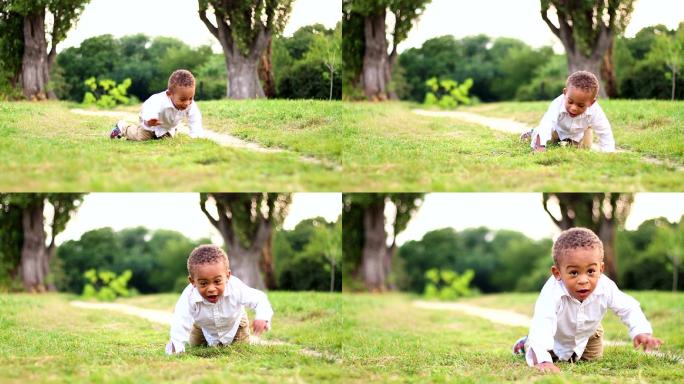 可爱小男孩在草地上玩耍和爬行