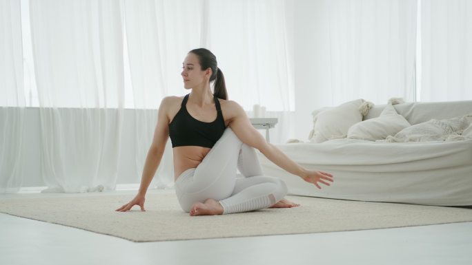 健身女士独自在家做伸展运动和练习瑜伽