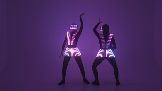 两个穿着紫外线服装的性感迪斯科舞女