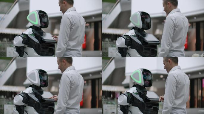 一个男人与一个白色机器人交流
