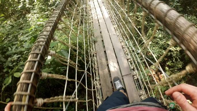 在丛林中，一名男子越过吊桥