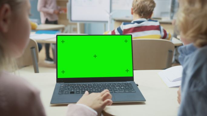 两个孩子在课堂上使用笔记本电脑