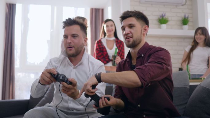 游戏玩家朋友坐在沙发上玩电子游戏