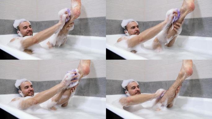 男子躺在浴缸里用泡沫和海绵清洗身体