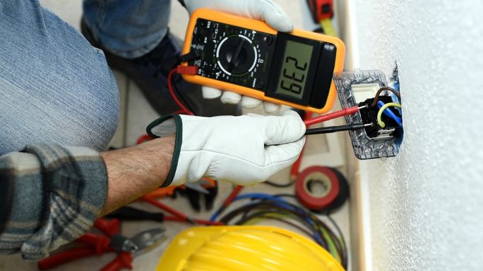 电工使用测试仪测量电气系统中的电压
