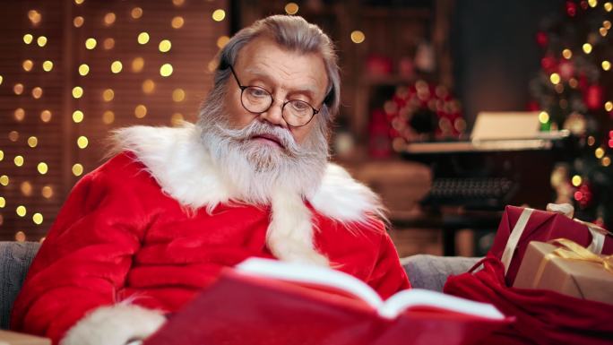圣诞老人正读着圣诞祝福的红皮书。