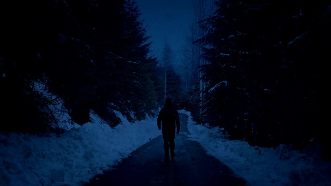 傍晚沿着雪路行走的人