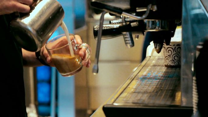 咖啡师在繁忙的咖啡店用咖啡机煮咖啡