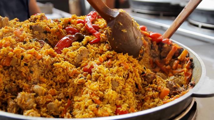 厨师将米饭与肉和蔬菜混合。