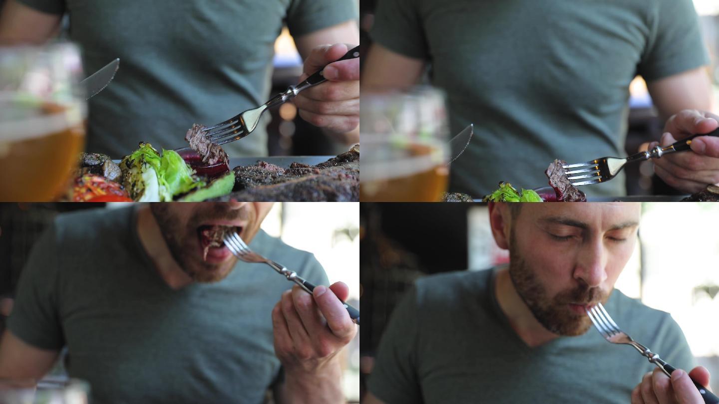 男人切牛排肉，蘸酱吃的特写镜头