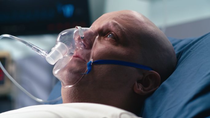 悲伤的癌症患者在医院呼吸氧气