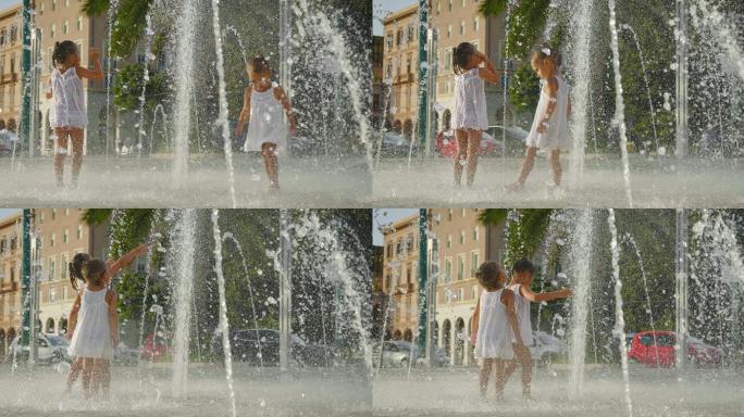 两个小女孩在喷泉里玩得很开心