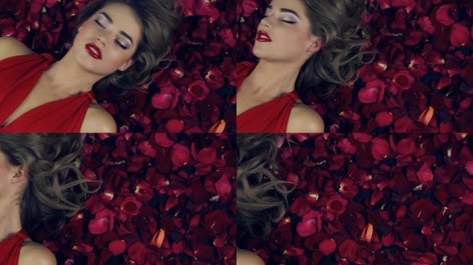 穿红衣服的女孩躺在红玫瑰的花瓣里。