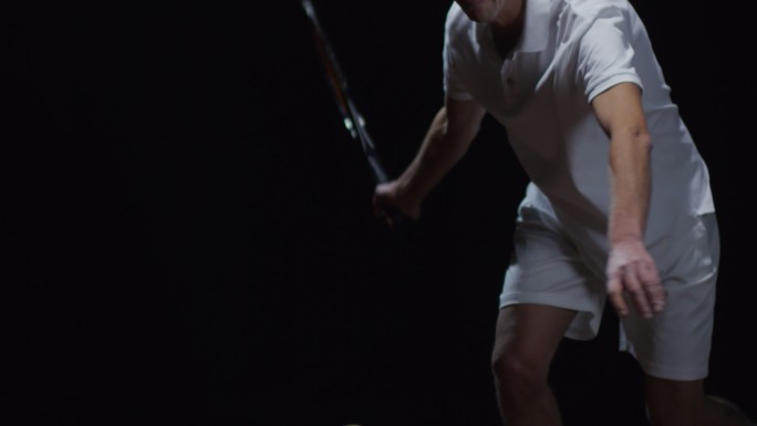 在黑色背景上击球的网球运动员