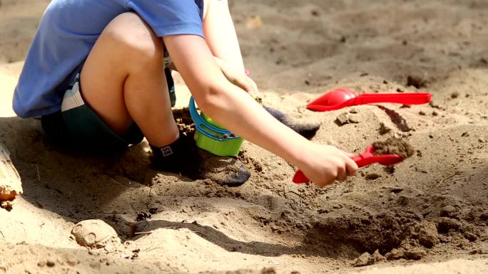 一个男孩在玩铲沙子