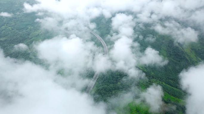 航拍白云下绿色屏障中的京昆高速