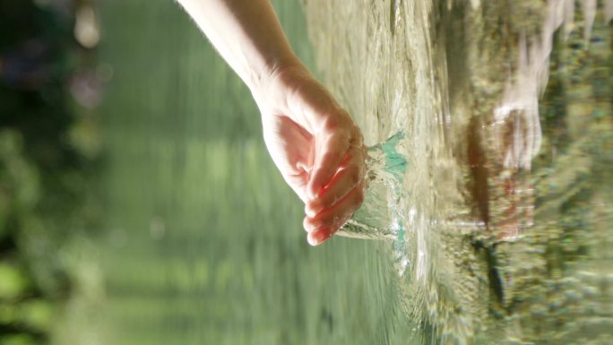 慢镜头特写：手握住并滴下纯净的淡水