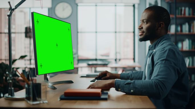 在客厅里用带绿色屏幕电脑模拟显示的男人