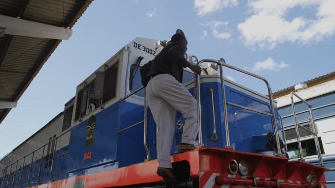 非洲火车司机爬上火车头驾驶室