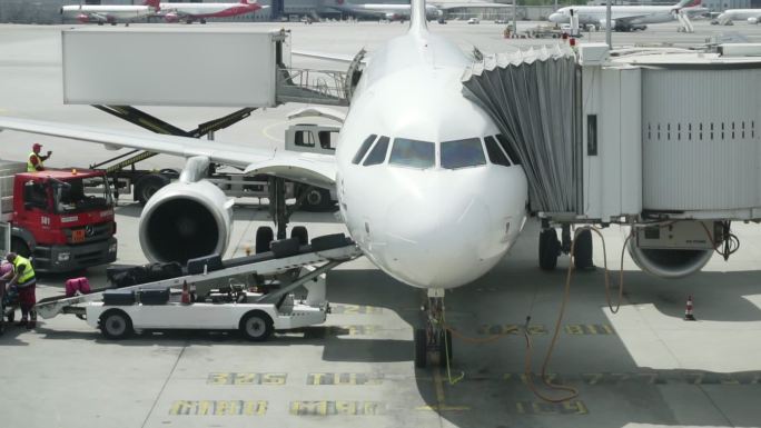 机场工作人员将行李放在飞机传送带上