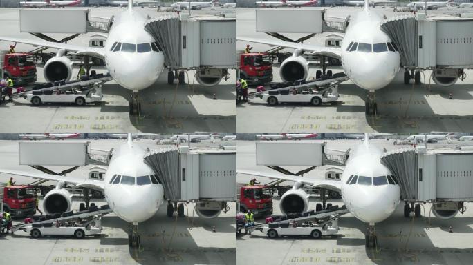 机场工作人员将行李放在飞机传送带上