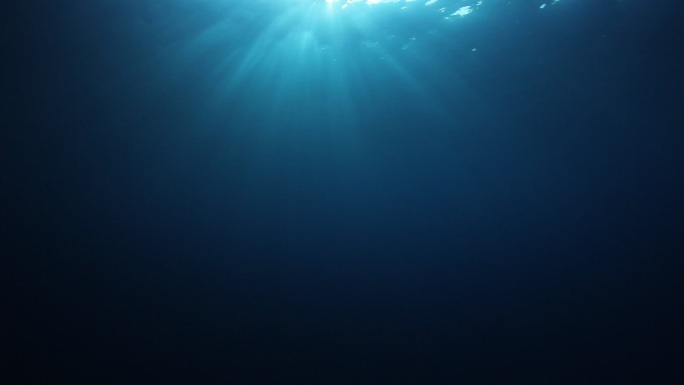 阳光和光线照射到蓝色的海水中