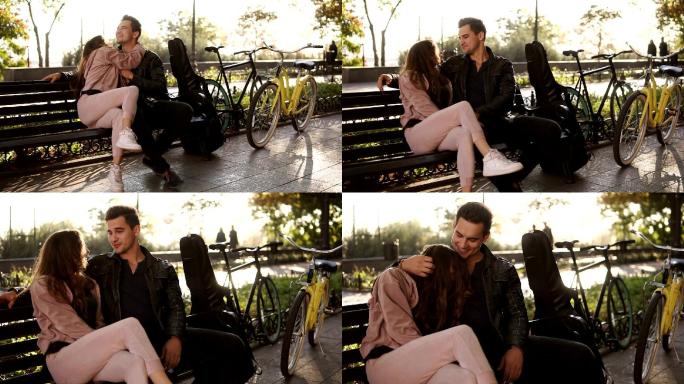 一对美丽的夫妇坐在公园的长椅上拥抱