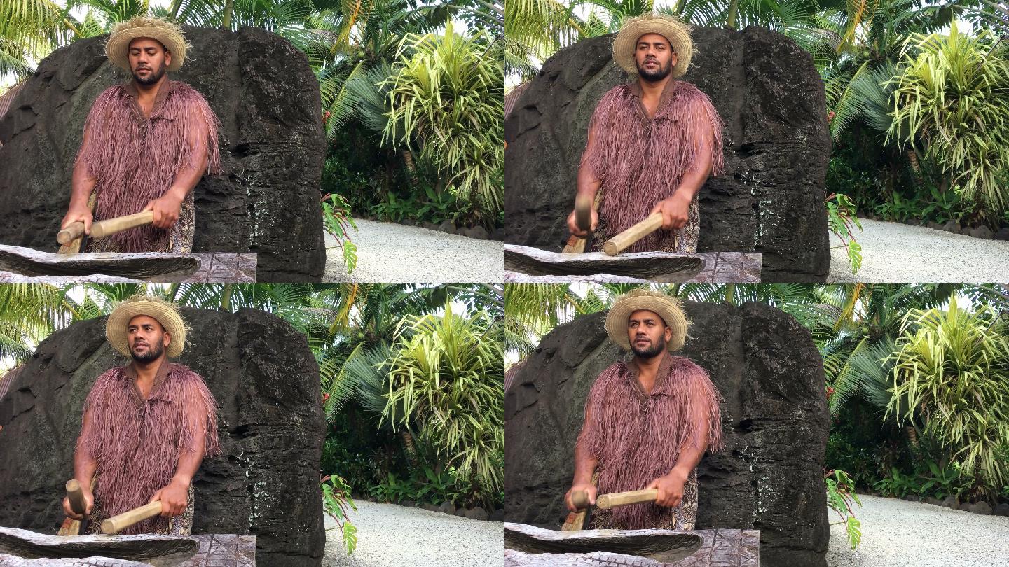 太平洋岛民在一个大的木制圆头鼓上演奏