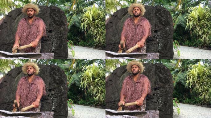 太平洋岛民在一个大的木制圆头鼓上演奏