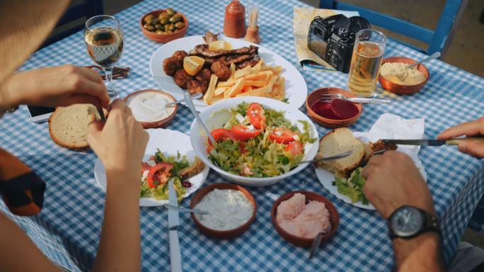 年轻游客夫妇在传统的希腊餐厅吃午餐
