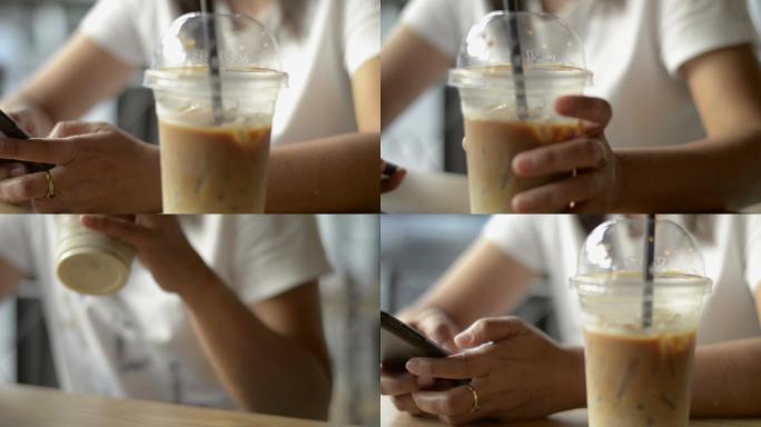 女性在咖啡厅喝冷饮时，使用手机