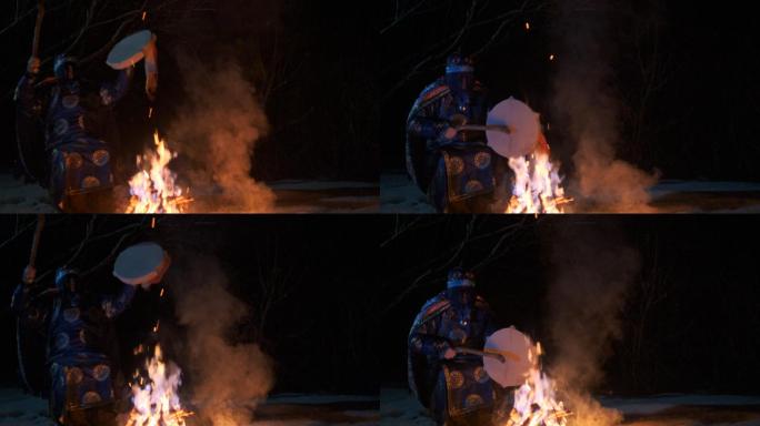 萨满坐在火炉旁，手里拿着手鼓，摇摇晃晃。