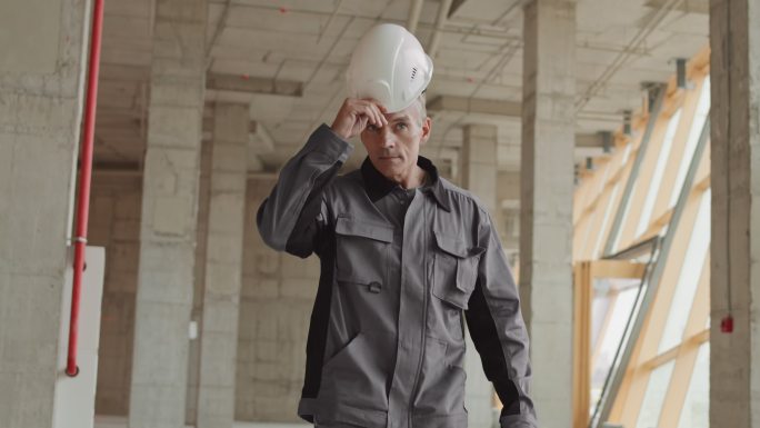 自信的建筑工人戴头盔走路