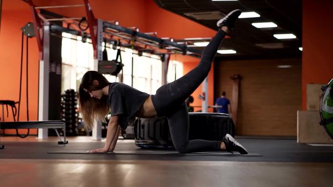 女性在大型现代健身房锻炼腿部和臀部