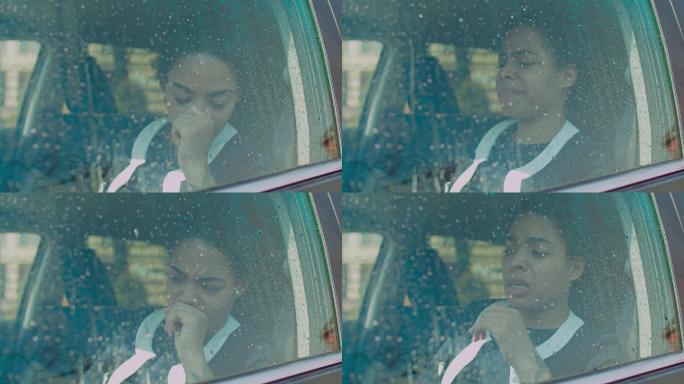 悲伤的女人透过车窗望着雨滴