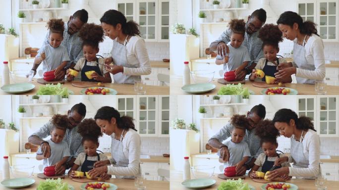 快乐的父母教孩子们在厨房切沙拉