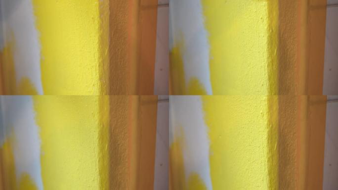 油漆工用刷子刷粗糙的水泥墙。