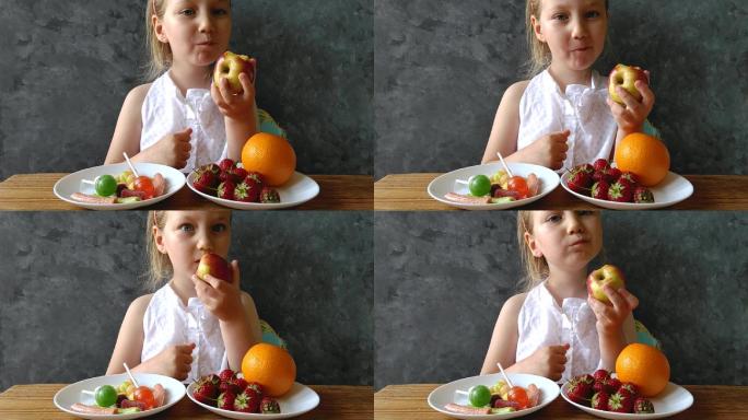 家里桌子上摆着新鲜水果和糖果的小女孩。