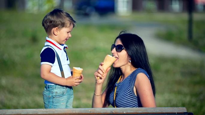 母亲和孩子夏天在户外吃冰淇淋